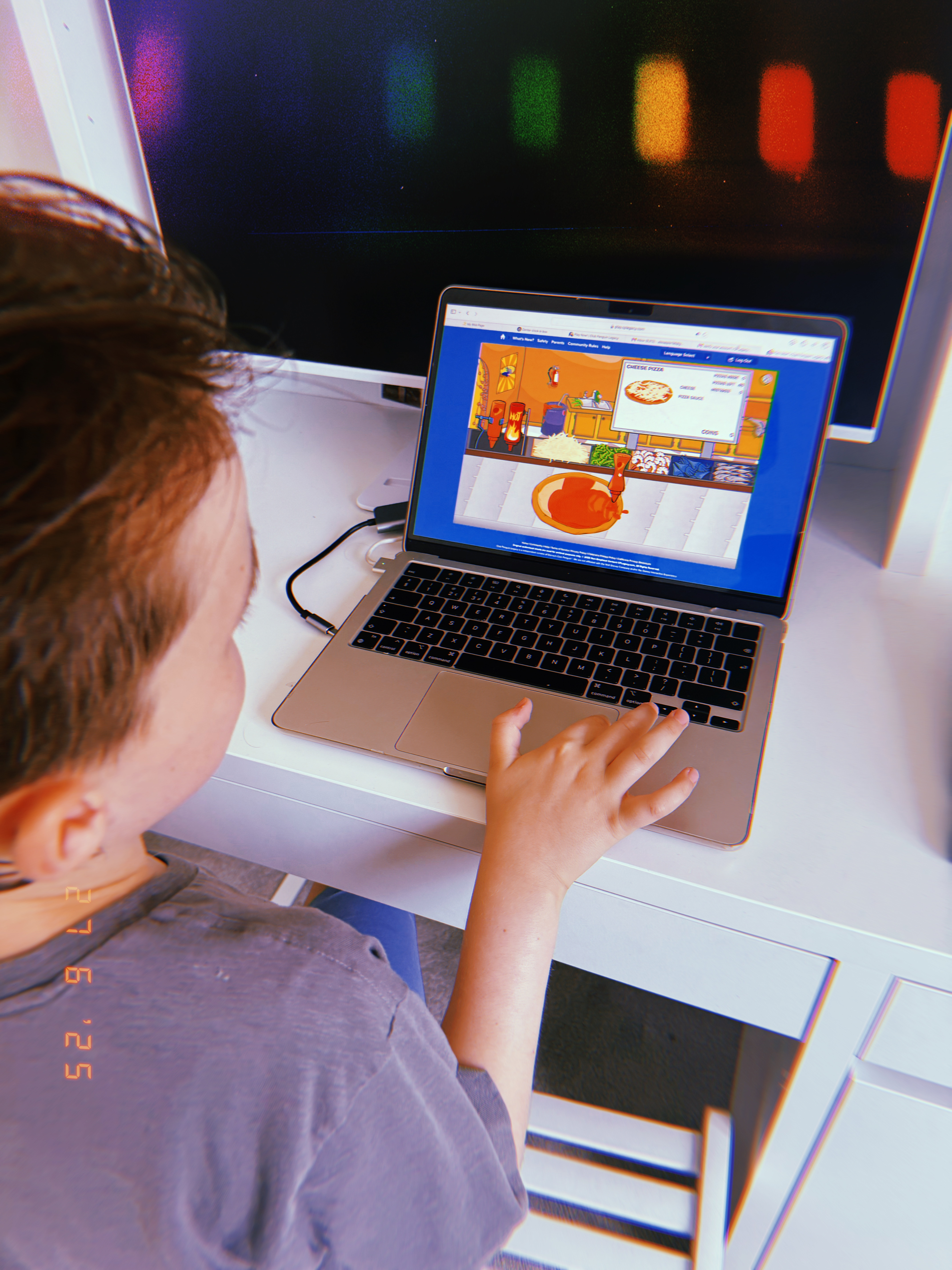 'child playing on club penguin on a macbook