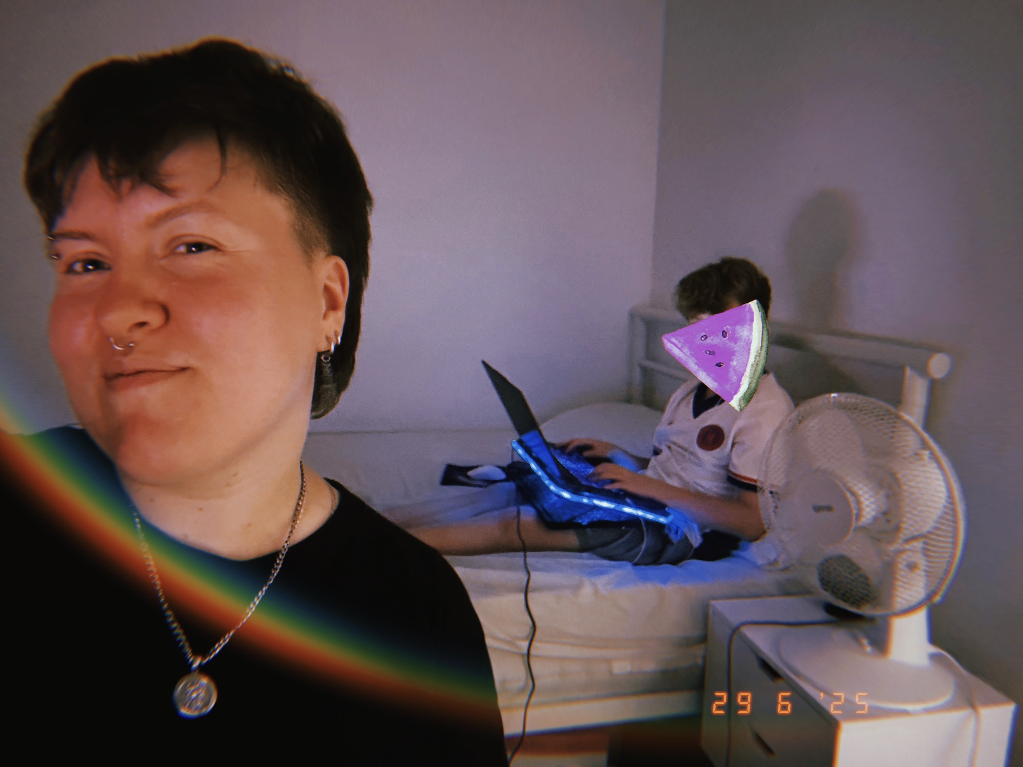 kid sitting on bed playing laptop with queer looing person holding camera selfie style